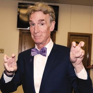 Visiting author and television host Bill Nye holds up both hands in the two-fingered Go Frogs hand gesture.